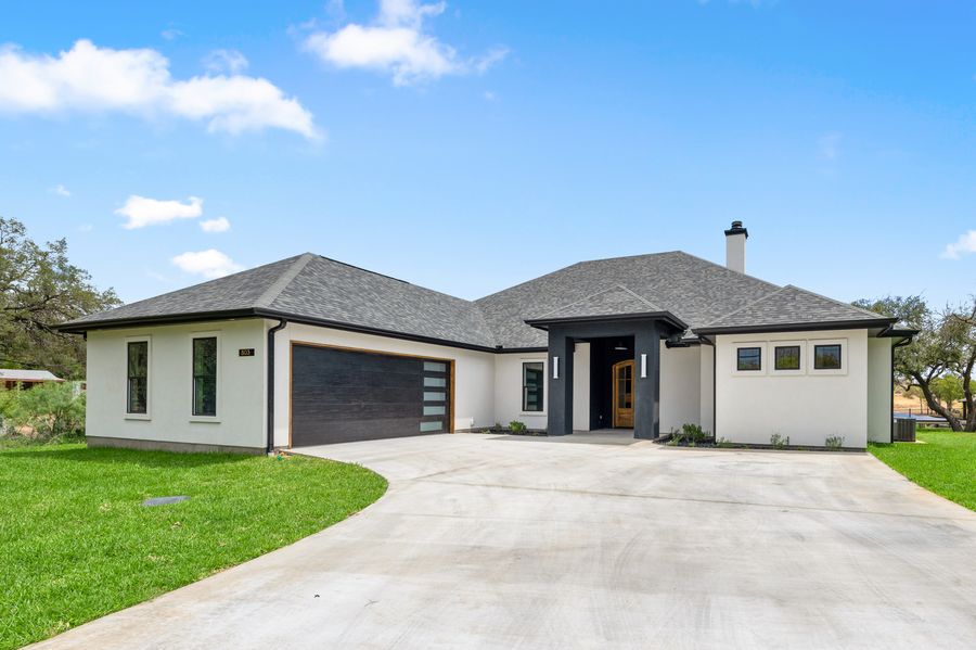 308 Belaire Drive: exterior with limestone boulder and live oak shade