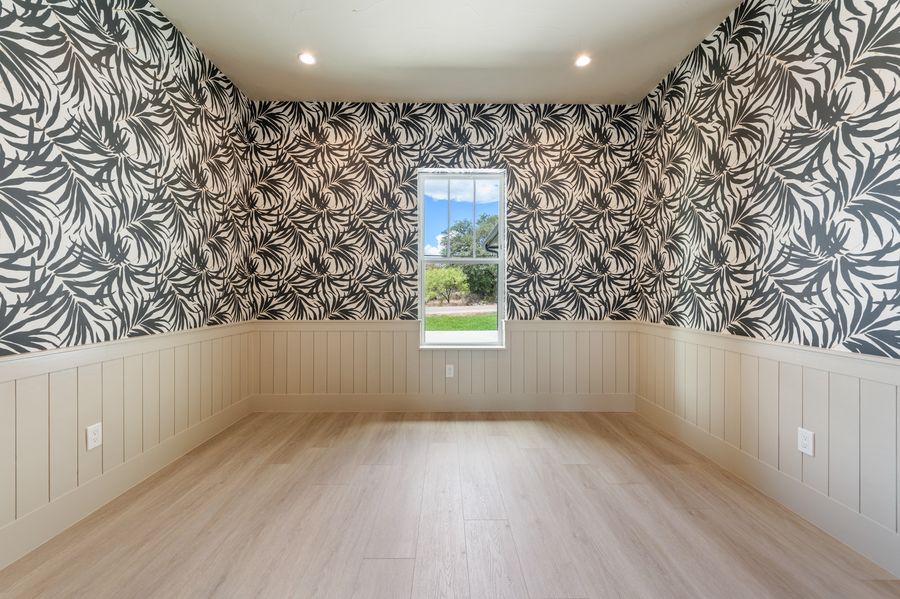 Statement room with bold black-and-cream palm wallpaper and shiplap wainscoting