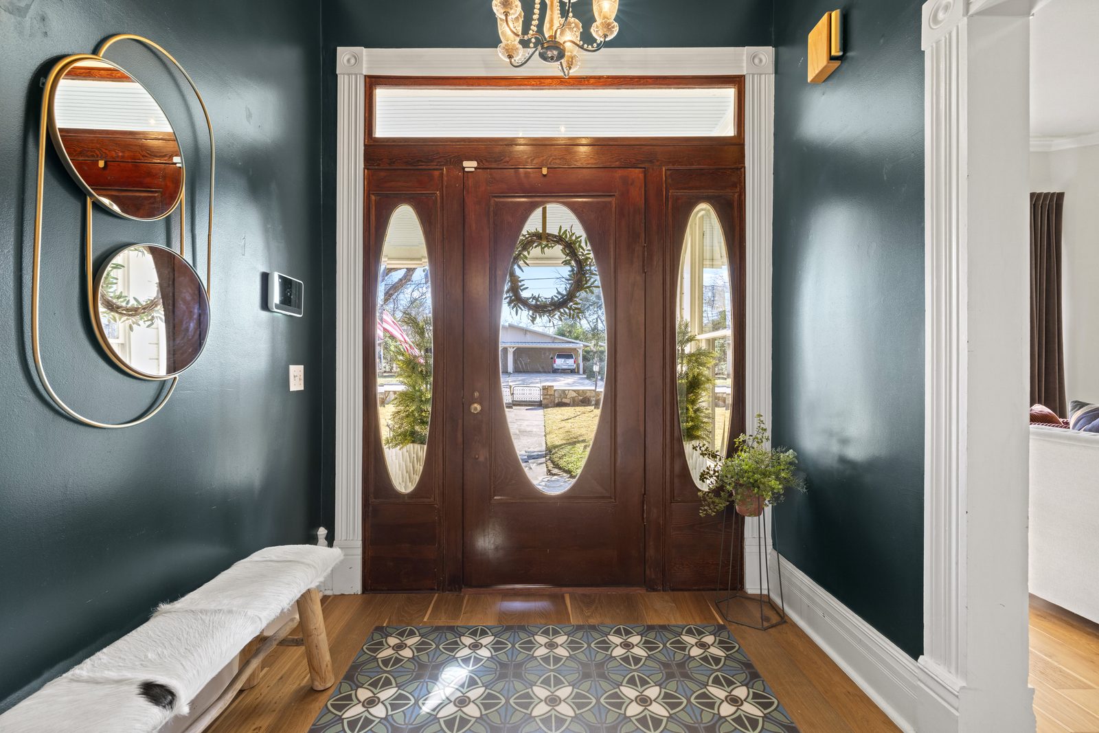 409 E Main: deep teal entryway with patterned encaustic tile floor and oval-window front doors