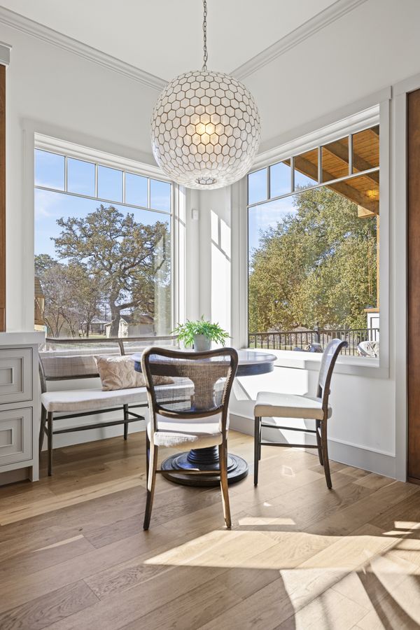 Breakfast nook with banquette seating, globe pendant light, and tall windows