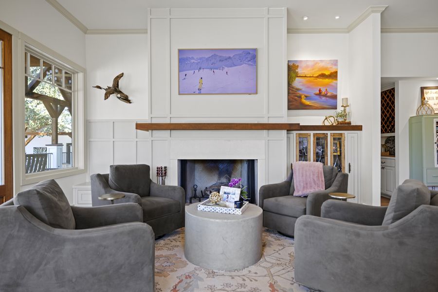 Living room with white-paneled fireplace and a circle of gray armchairs