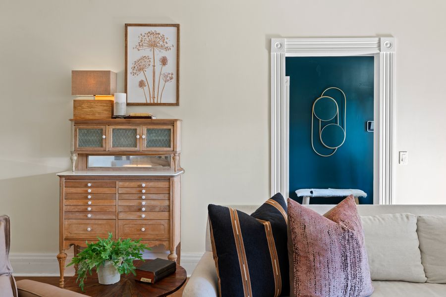 Vintage credenza vignette with peek into a deep-blue powder room