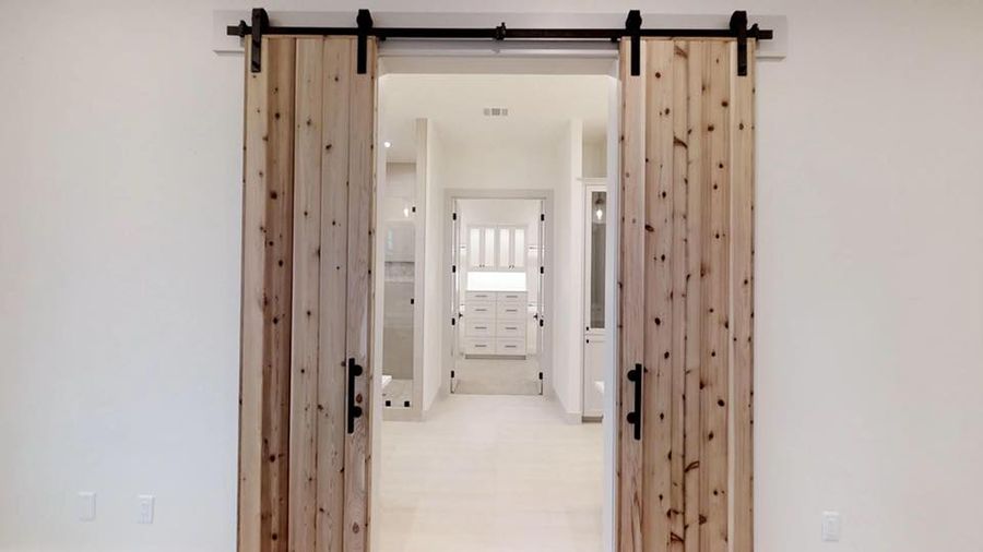 Knotted cedar barn doors opening to the master suite