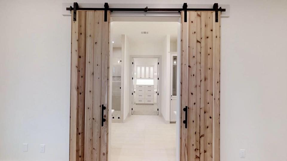Cypress 8: knotted cedar barn doors opening to the master suite